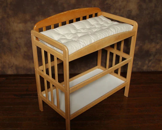 Baby changing table pad by Holy Lamb Organics, soft cushioned surface with waterproof cover for comfortable diaper changes.