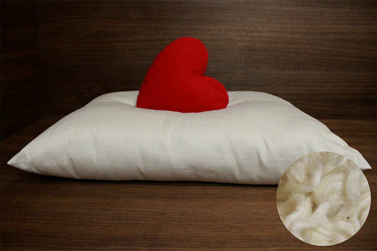 Natural Kapok filling for Soaring Heart pillows, showing a close-up of soft, fluffy kapok fibers in a circular arrangement.