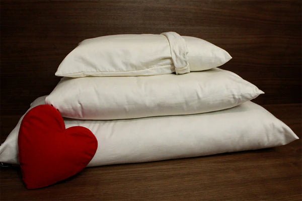 Natural Kapok Pillows by Soaring Heart, plush pillows with soft, breathable kapok filling shown on a bed.