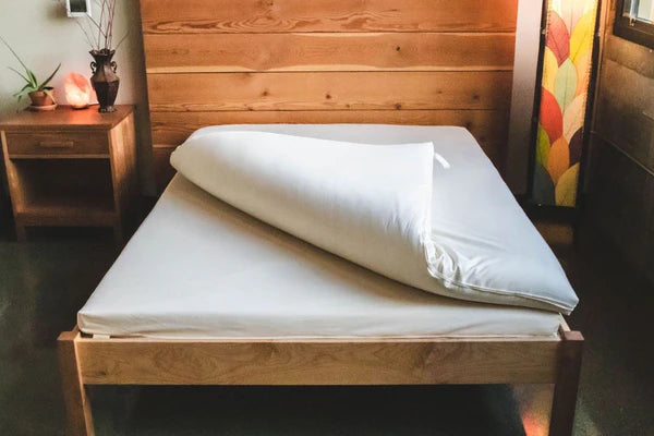 Wool and latex Shikibuton mattress by Holy Lamb Organics with a plush top and natural fabric, displayed on a bed.