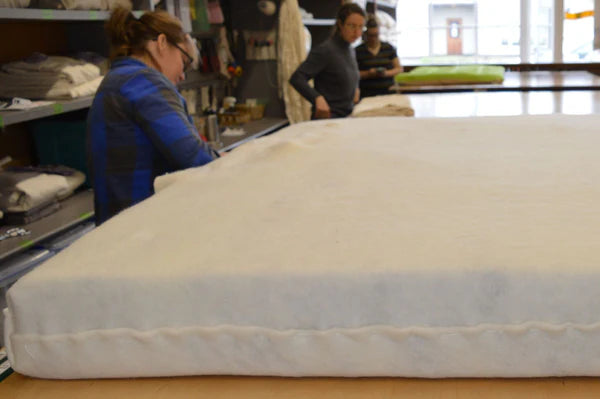 Holy Lamb Organics Wool and Latex Mattress 6.5-inch thick, showing the layered wool and latex materials in a clean, cozy bedding setup.