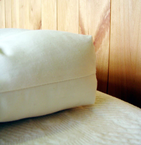 Natural wool baby bassinet mattress by Holy Lamb Organics, showing soft, plush wool filling and a cozy, breathable mattress surface.