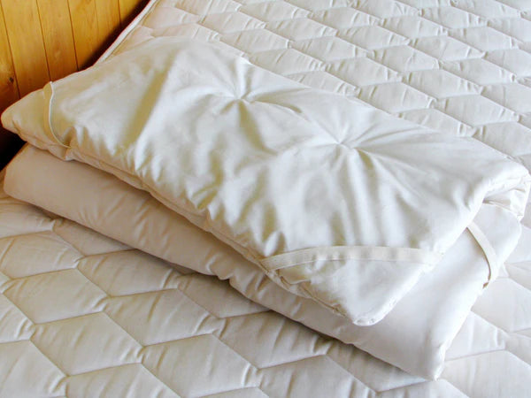 Folded Holy Lamb Organics certified organic baby crib mattress topper showing soft, eco-friendly fabric and plush surface.