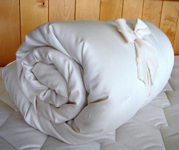 Certified organic baby crib mattress topper from Holy Lamb Organics, rolled for easy handling and added comfort.