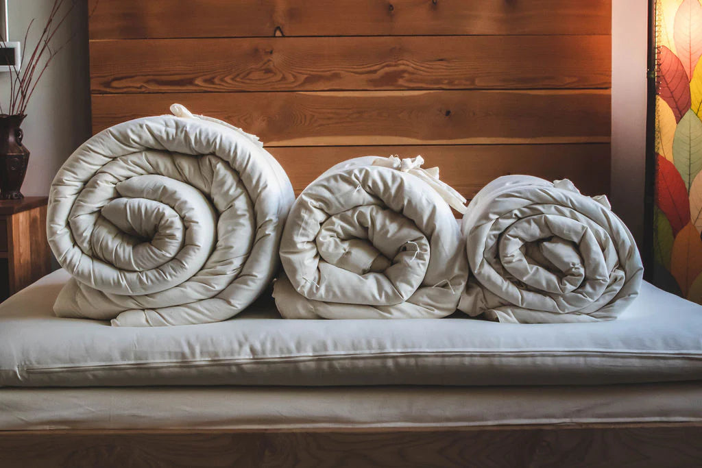 All-natural wool comforter rolled for bedding, soft and cozy with a textured surface, ideal for bedroom comforters and sets.