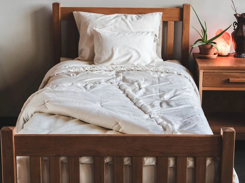 All-natural wool comforter turned back on a bed, showcasing its soft, plush texture and cozy appearance for bedroom comfort.