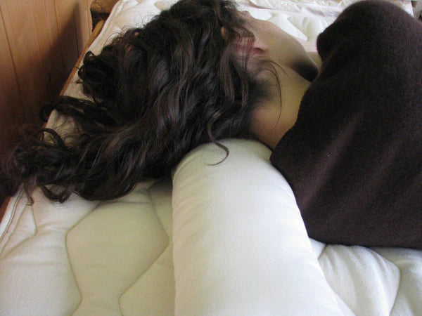 Holy Lamb Organics neck roll pillow with soft fabric cover and ergonomic shape for neck support and comfort.