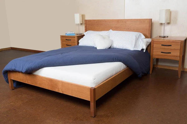 Organic latex mattress by Soaring Heart showing a neatly made mattress with a white fitted sheet and a cozy, inviting bedroom setting.