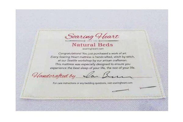 Organic latex mattress by Soaring Heart with plush, natural latex surface and supportive design, shown in a cozy bedroom setting.