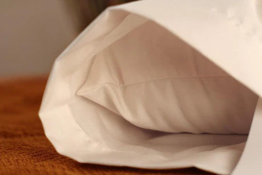 Soaring Heart organic sateen pillow cases on bed pillows, showcasing soft, smooth, and luxurious white bedding with elegant stitching