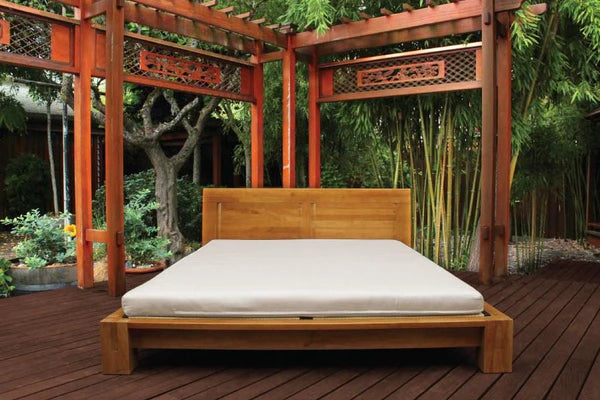 Organic latex shikibuton mattress from Soaring Heart, shown rolled out on a bed, with a smooth, natural fabric cover.
