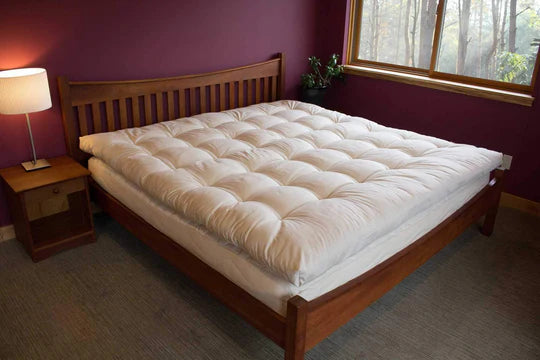 Organic quilted mattress topper by Holy Lamb Organics, plush and cushioned for added comfort on bed.