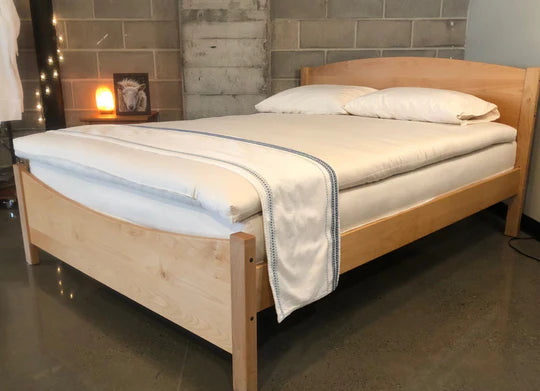 Holy Lamb Organics Wool and Latex Mattress Topper on a bed, showcasing plush, natural bedding for added comfort and support.