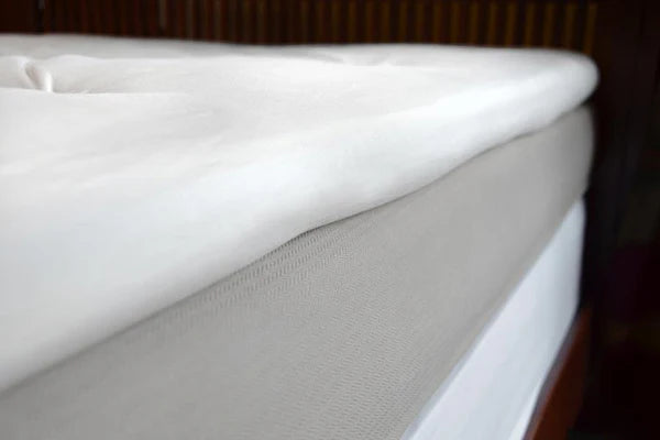 Organic latex mattress topper from Soaring Heart, showing the plush, natural latex surface on a comfortable bed.