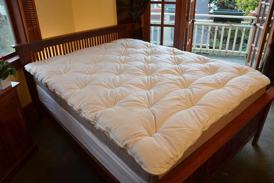 Organic Wool Mattress Topper by Soaring Heart, showing a plush, natural wool top layer on a bed for added comfort.