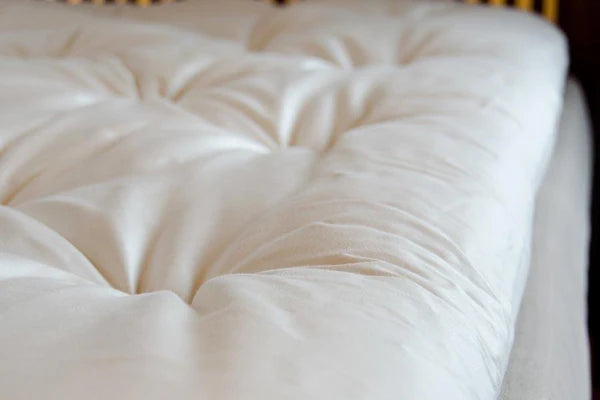Organic wool mattress topper from Soaring Heart, plush and breathable bedding layer for enhanced comfort and natural sleep support.